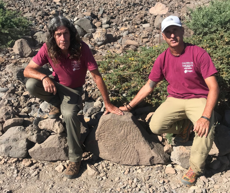 Antonio y Álvaro junto al grabado rupestre (Foto Jorge Pais)
